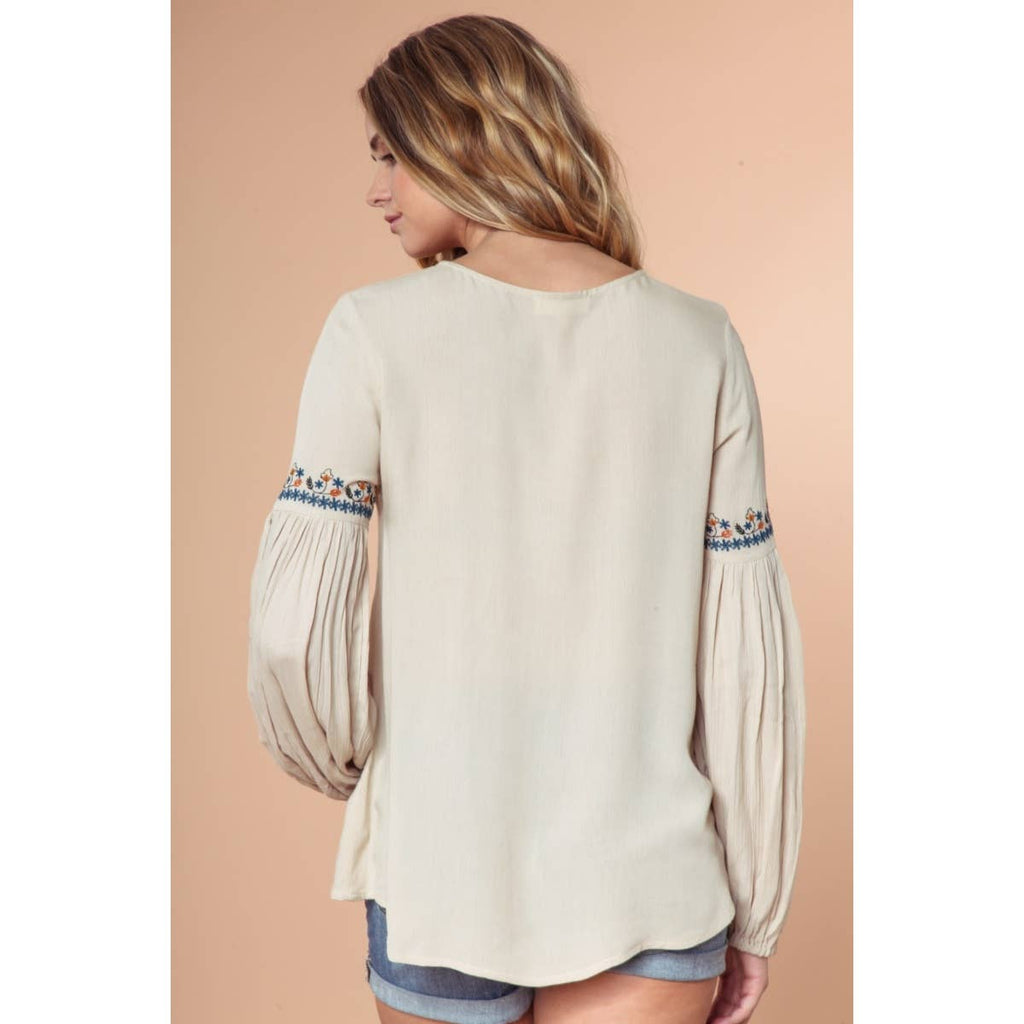 Blusa de manga larga con cordones y bordado.